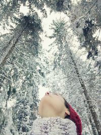 Close-up portrait of young woman against trees