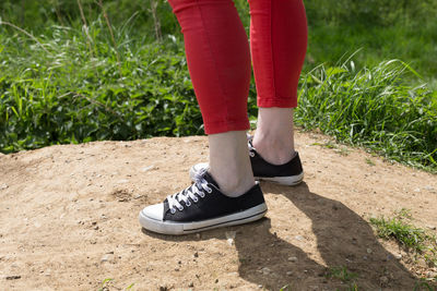 Low section of person wearing canvas shoes on sunny day