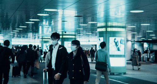 Group of people walking on illuminated road in city