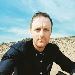 Portrait of man on beach against sky