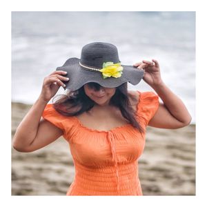 Midsection of woman wearing hat on beach