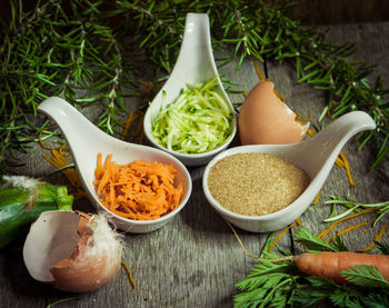 High angle close-up of food in spoons on wooden table