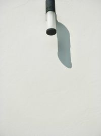 Close-up of electric lamp against white wall