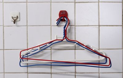 Close-up of coathangers hanging on hook in bathroom