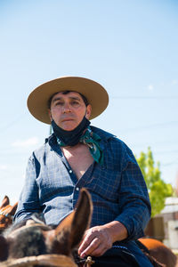 Portrait of man wearing hat against sky