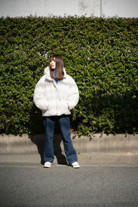 Full length of young woman walking on road