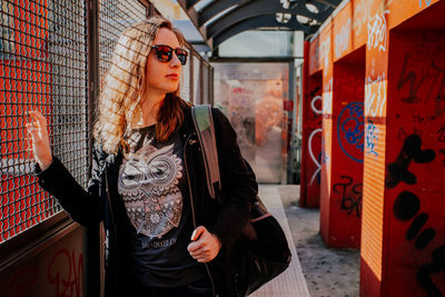 Portrait of young woman standing in city