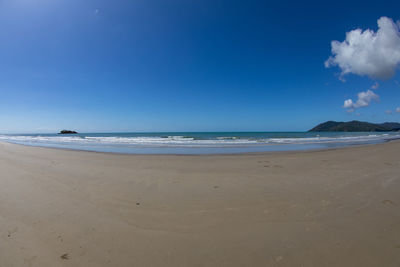 Scenic view of beach against blue sky