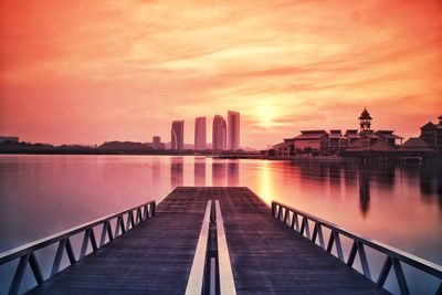 Buildings at waterfront during sunset