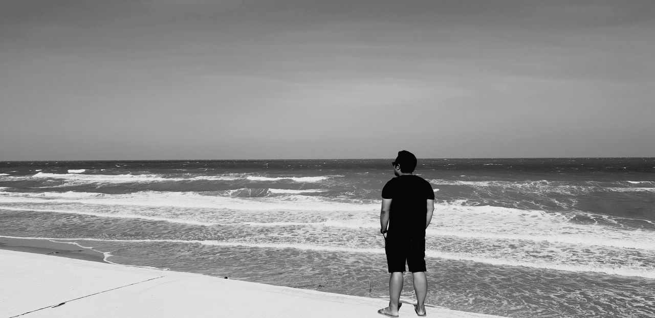 sea, water, horizon over water, horizon, sky, rear view, real people, one person, scenics - nature, beauty in nature, lifestyles, leisure activity, standing, land, beach, wave, men, nature, motion, outdoors, looking at view