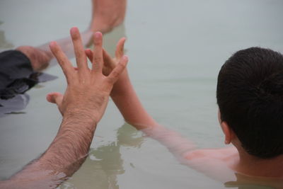 Cropped image of father and son relaxing in dead sea