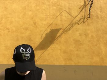 Portrait of person wearing mask against wall