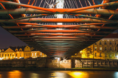 Illuminated bridge over river at night