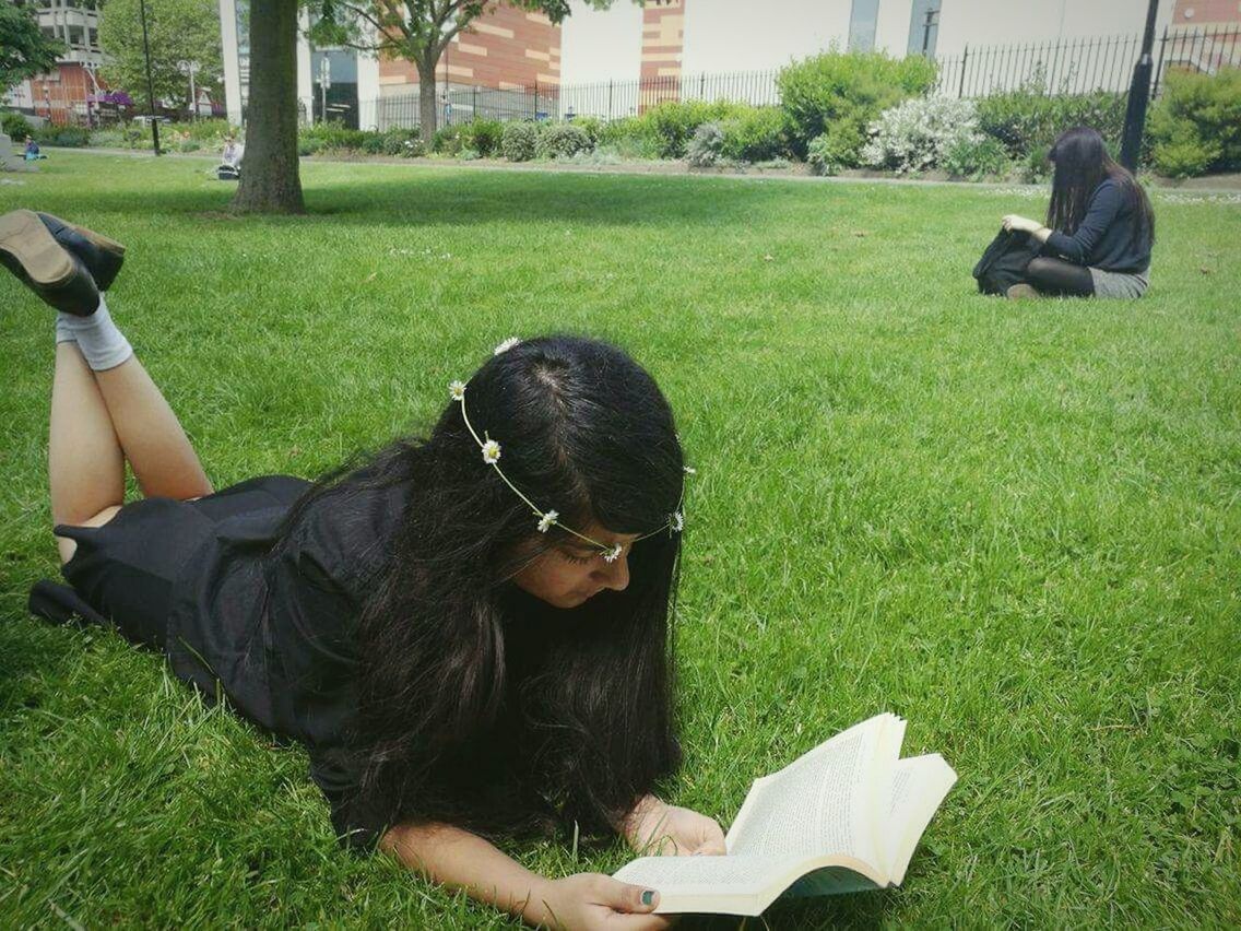 PEOPLE RELAXING ON GRASSY FIELD IN PARK