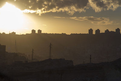 Silhouette buildings against sky during sunset