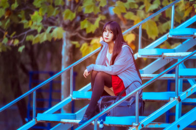 Portrait of young woman sitting on staircase