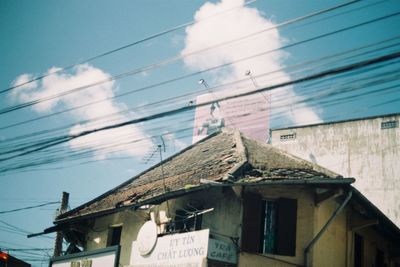Low angle view of text on roof against sky