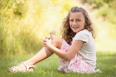 Portrait of smiling girl sitting on grass