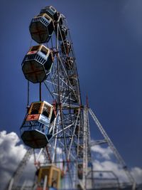 Low angle view of ferris wheel against blue sky