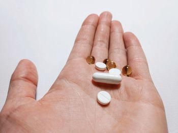 Close-up of person holding hands over white background