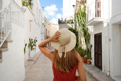 Traveler girl walks through the alleys in a picturesque town in apulia region, italy