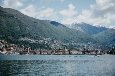 Scenic view of townscape by mountains against sky