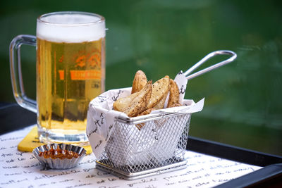 Close-up of potato wedges and beer in tray