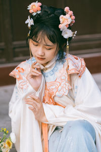 Midsection of woman holding red flowering plant