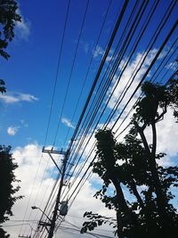 Low angle view of electricity pylon against cloudy sky