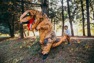 Full length of father and son on road in forest