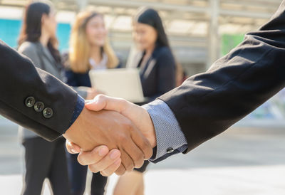 Midsection of couple holding hands