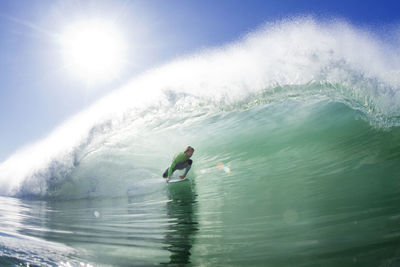 Man surfboarding in sea against sky