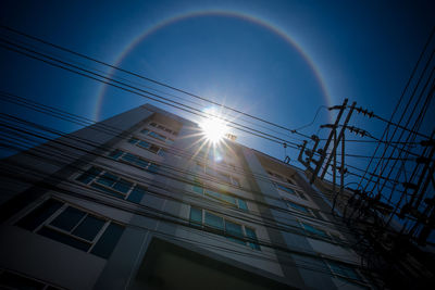 Low angle view of rainbow over buildings against sky