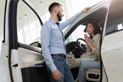 Portrait of young woman sitting in car