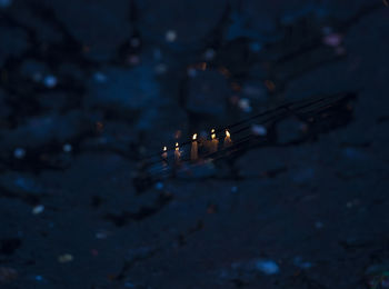 High angle view of lit candles in darkroom