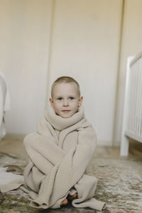 Boy wearing oversized sweater at home