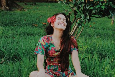 Full length of a smiling young woman on field