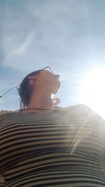 Low angle view of woman against sky on sunny day