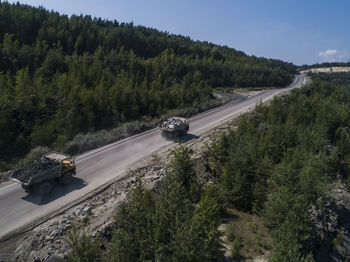 High angle view of vehicles on road along trees