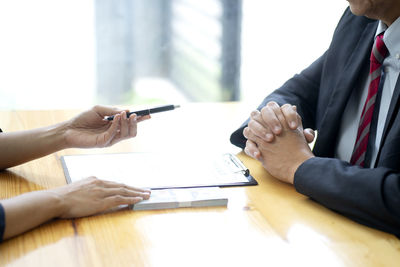 Cropped image of man holding hands on table