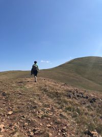 Rear view of man on land against sky