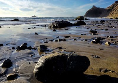 Rocks on beach against sky