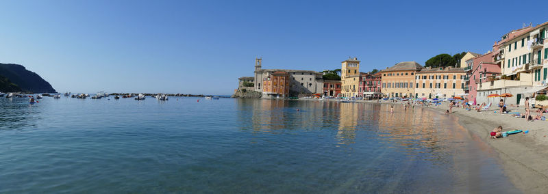 View of buildings in city against clear blue sky