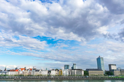 Buildings in city against cloudy sky