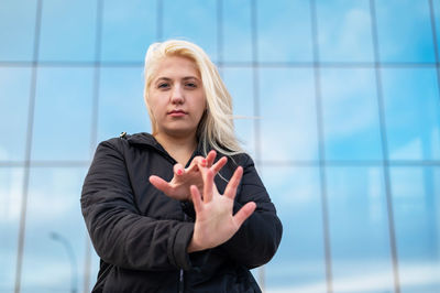 Portrait of woman standing against wall