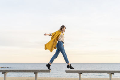 Full length of woman standing on sea against sky