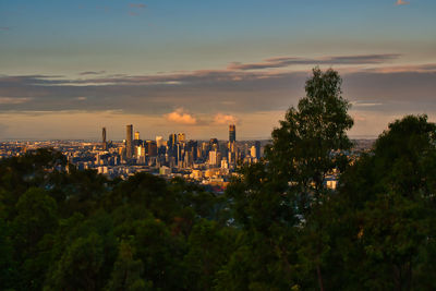 Panoramic view of trees and buildings against sky during sunset