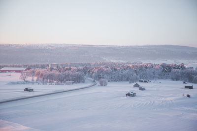 Scenic view of snow covered field against sky