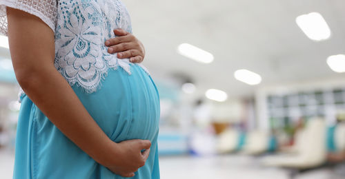 Midsection of pregnant woman standing at hospital