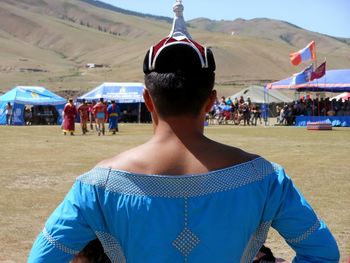Rear view of man wearing traditional clothing while standing against mountain
